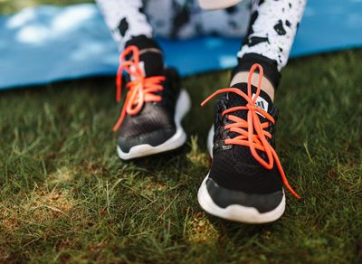 Close up on athletic shoes on a yoga mat.